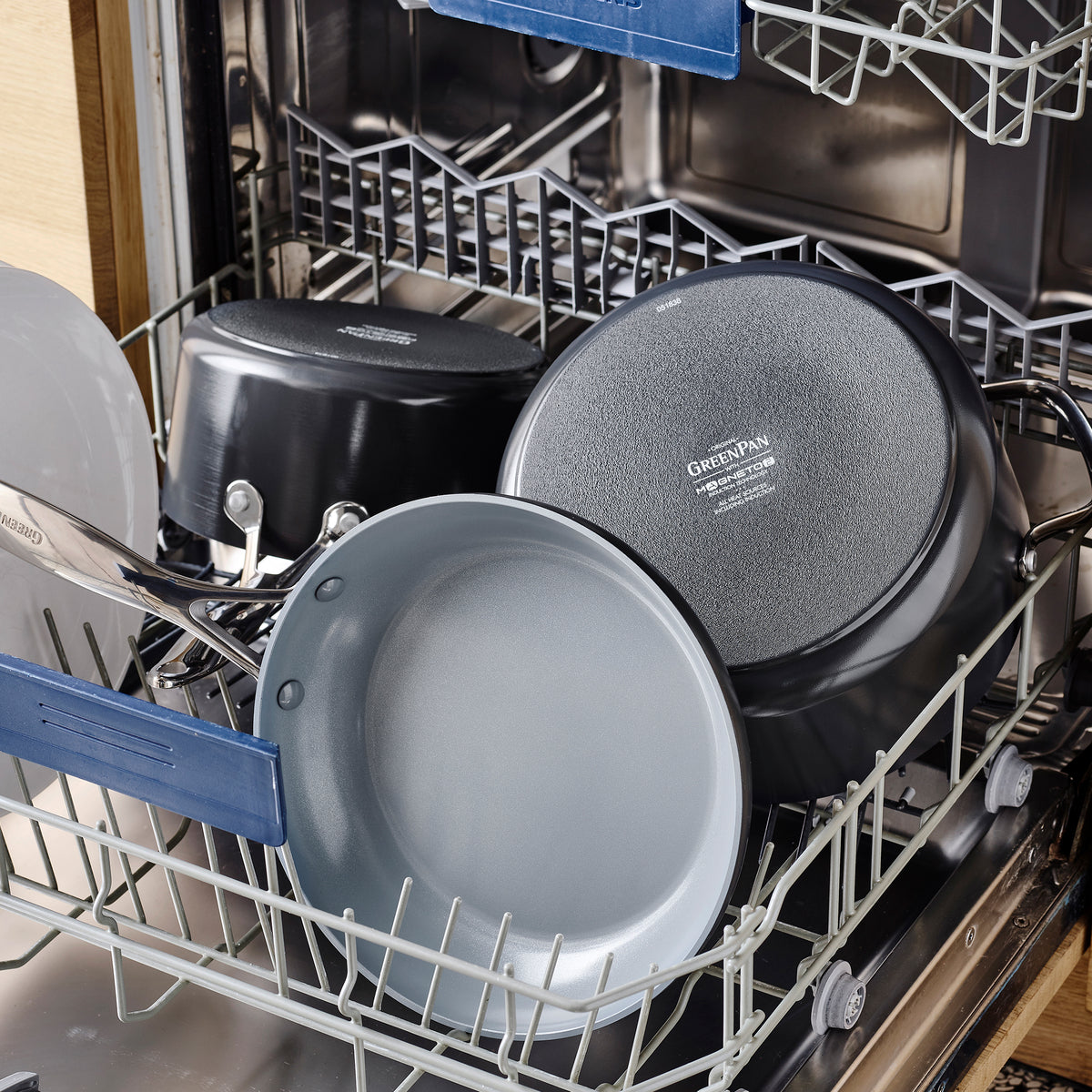Valencia Pro ceramic nonstick saucepan with lid and assorted cookware in the bottom rack of an open dishwasher.